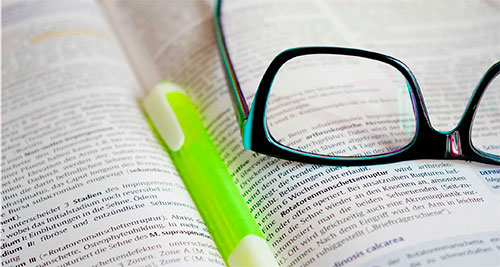 Gafas y bolígrafo sobre un libro abierto